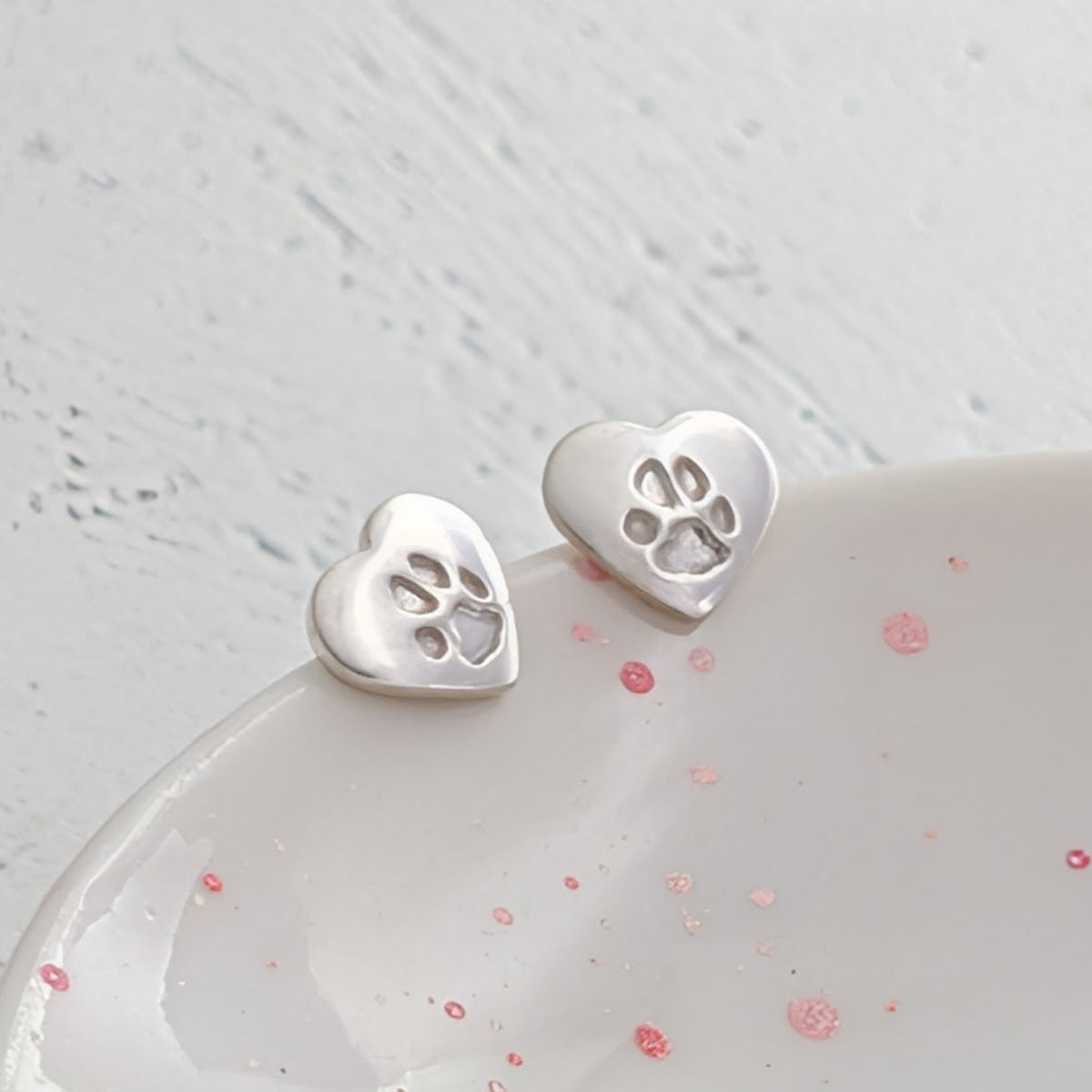 Custom pawprint jewellery earrings with delicate heart-shaped sterling silver studs engraved with your pet's paw print. Thoughtful pet loss gift and lasting memorial keepsake.