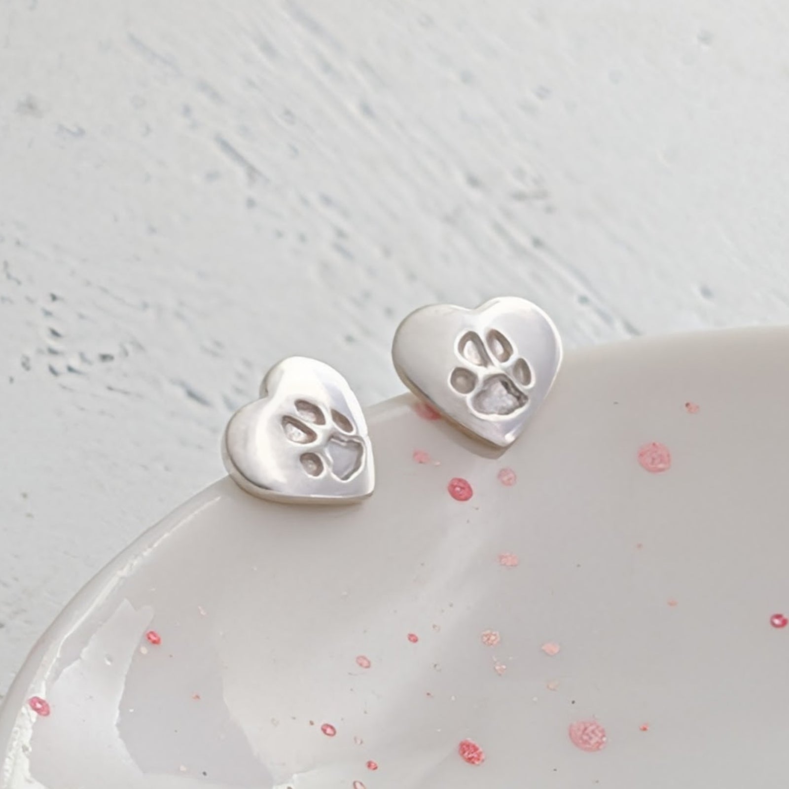 Custom pawprint jewellery earrings with delicate heart-shaped sterling silver studs engraved with your pet's paw print. Thoughtful pet loss gift and lasting memorial keepsake.