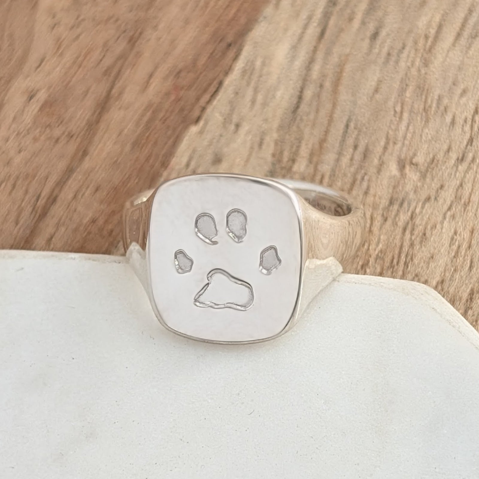 Sterling silver paw print signet ring handmade in the UK, personalised pet memorial jewellery featuring an engraved pawprint on a polished square signet face.